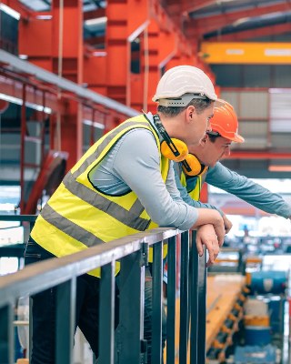 Two workers in hard hats on a factory floor